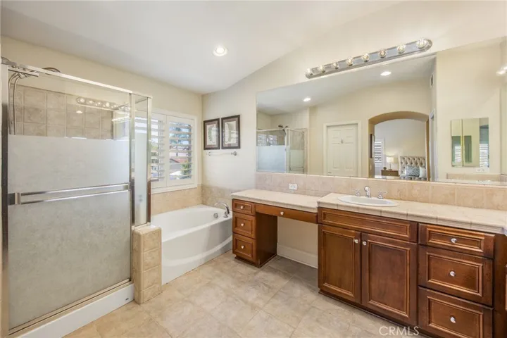 Spacious primary bathroom featuring a soaking tub, separate shower, and dual-sink vanity