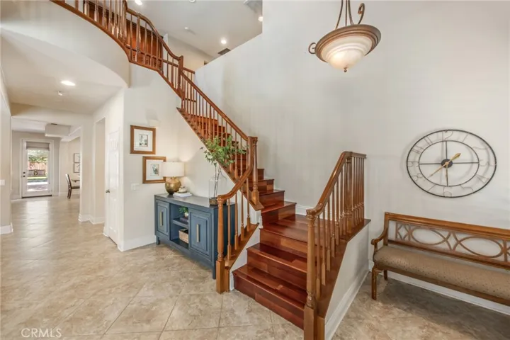 Grand entry with soaring ceilings and a sweeping staircase creating a striking first impression