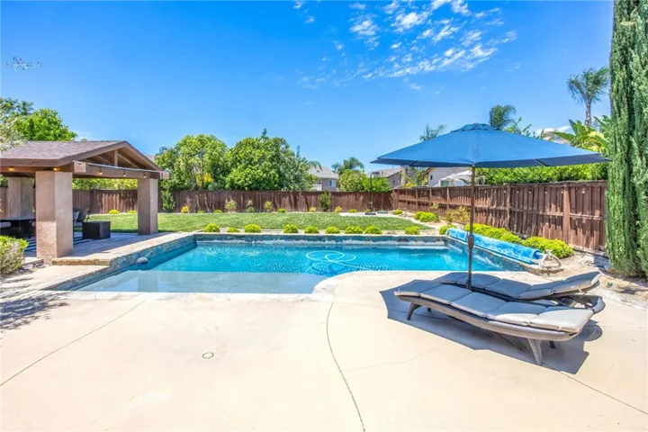 Resort-style pool and spa surrounded by a spacious patio and landscaped backyard