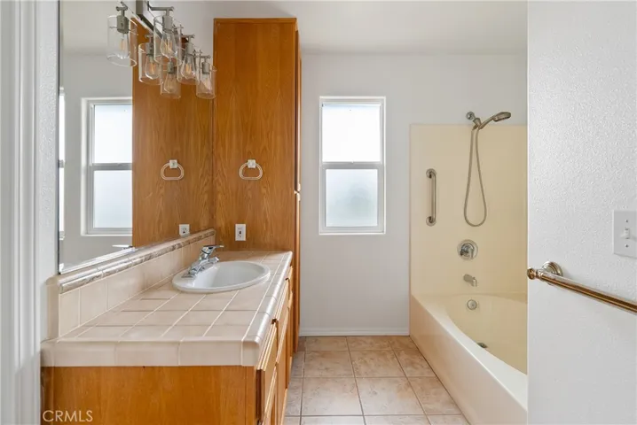 Primary bathroom with bath shower combination with lots of cabinet storage