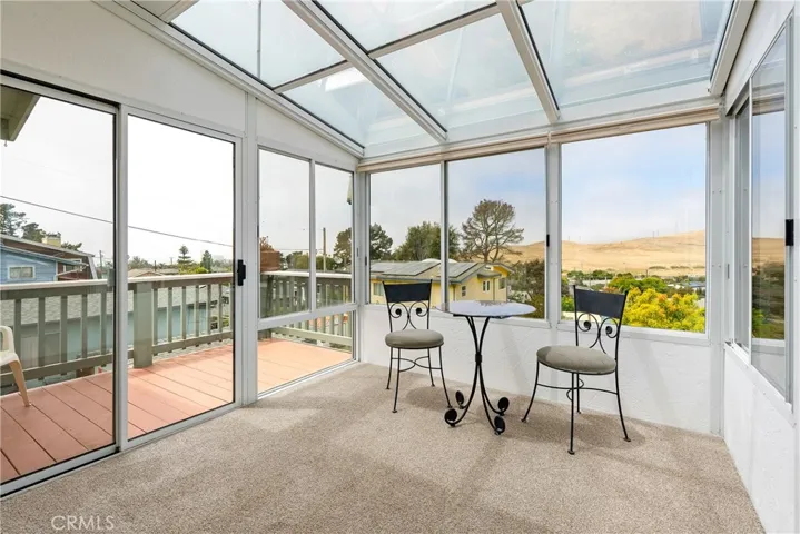 Versatile enclosed sunroom providing abundant natural light and direct access to the outdoor deck.
