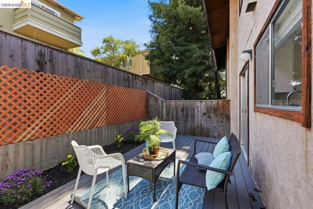 Private outdoor deck space featuring composite decking, a lattice privacy screen, and an adjacent stucco exterior