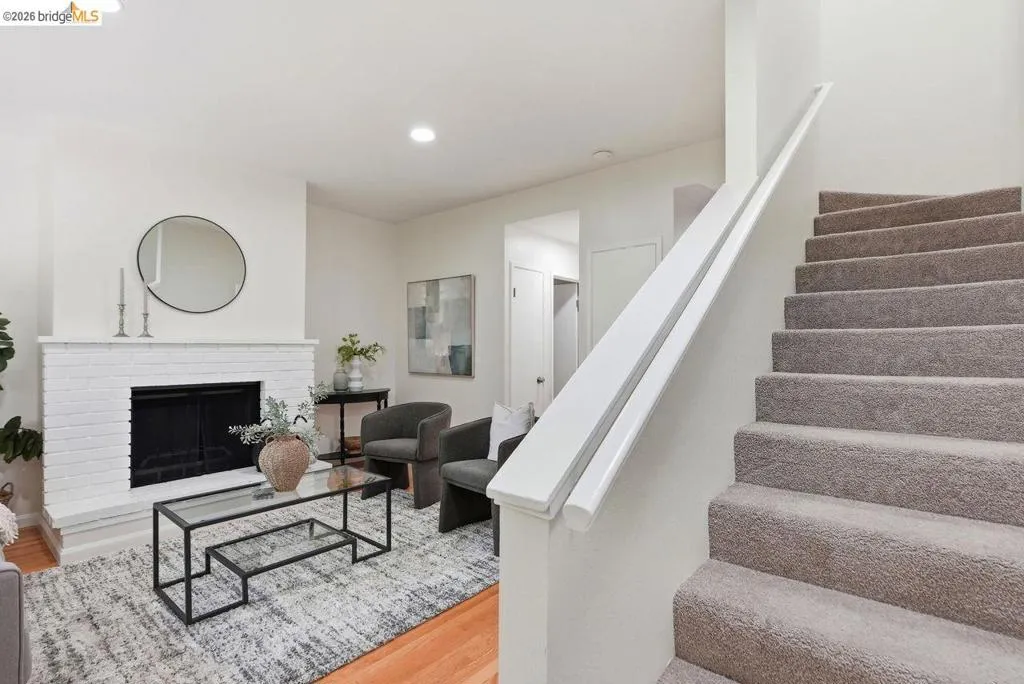 Living area featuring a painted brick fireplace, recessed lighting, and wood-finish flooring