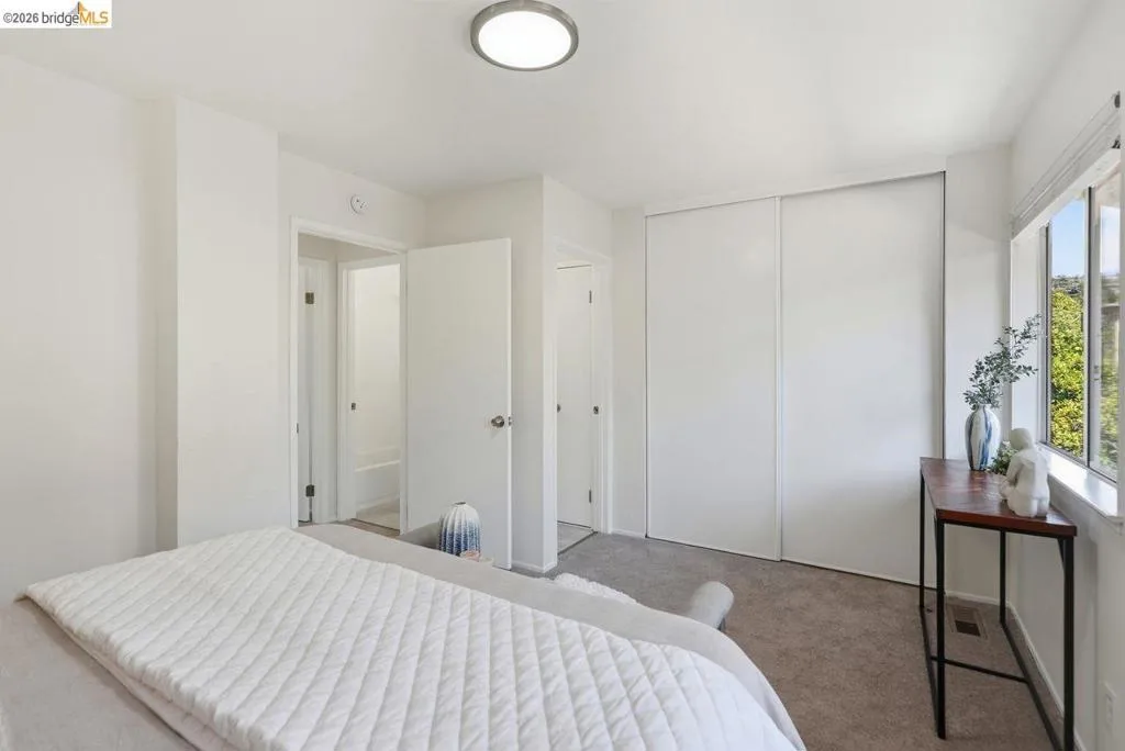 Room featuring light-toned carpeting, white walls, and a flush-mount ceiling light