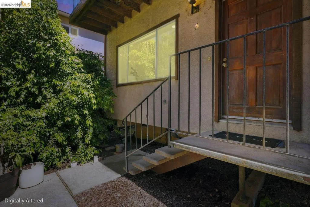 Exterior featuring a paneled wood entry door, stucco finish, and an exterior light fixture3s