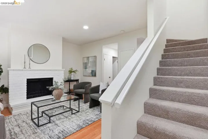 Living area featuring a painted brick fireplace, recessed lighting, and wood-finish flooring
