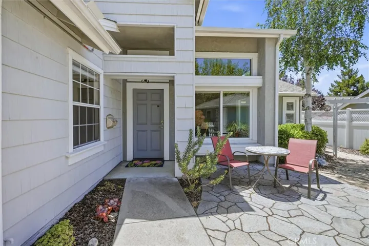 Inviting front entrance with patio and mature landscaping