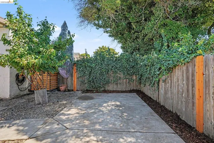 Outdoor patio space featuring a concrete slab and surrounding gravel