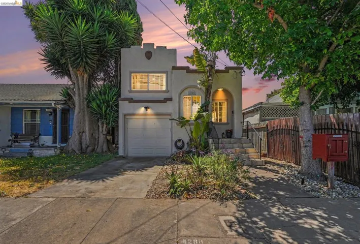 Stucco exterior with arched entry, integrated single-car garage, and established front landscaping