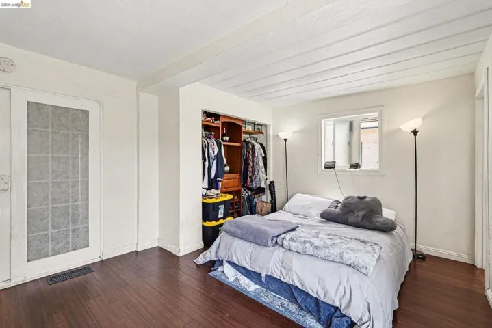 Bedroom featuring dark wood-finish flooring, white walls, and a white planked ceiling