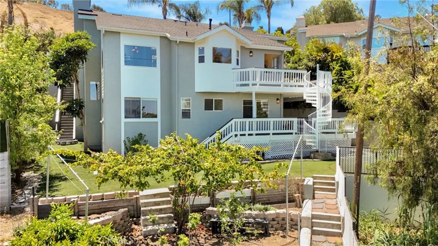 House rear framed by Mature trees and vegetation for  a pleasant backdrop.