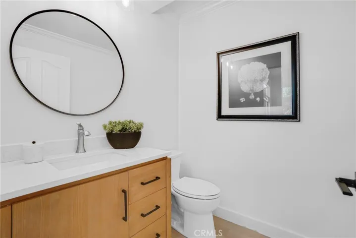 Updated Hall Bathroom with new vanity, mirror, toilet, flooring, fixtures, and reglazed tub/ shower walls.
