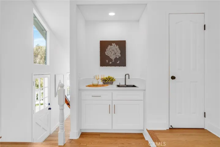 wet bar with new cabinet doors, sink, fixture and quartz countertop.