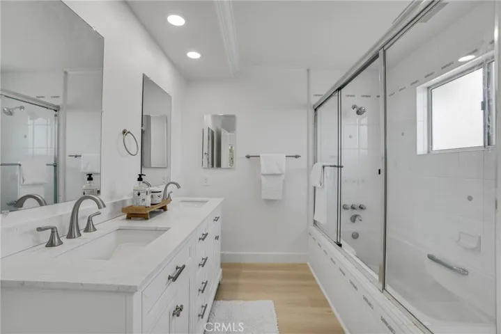 Primary Bathroom with updated vanity,medicine cabinet, mirrors, plumbing fixtures, flooring, new toilet, and more.