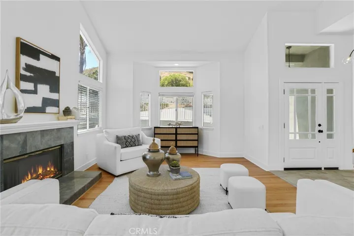 Living Room with bay style front windows, new front door, refinished hardwood floors.