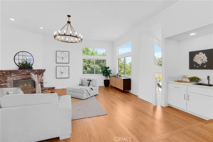 Family Room with view windows, brick gas fireplace, and wet bar.