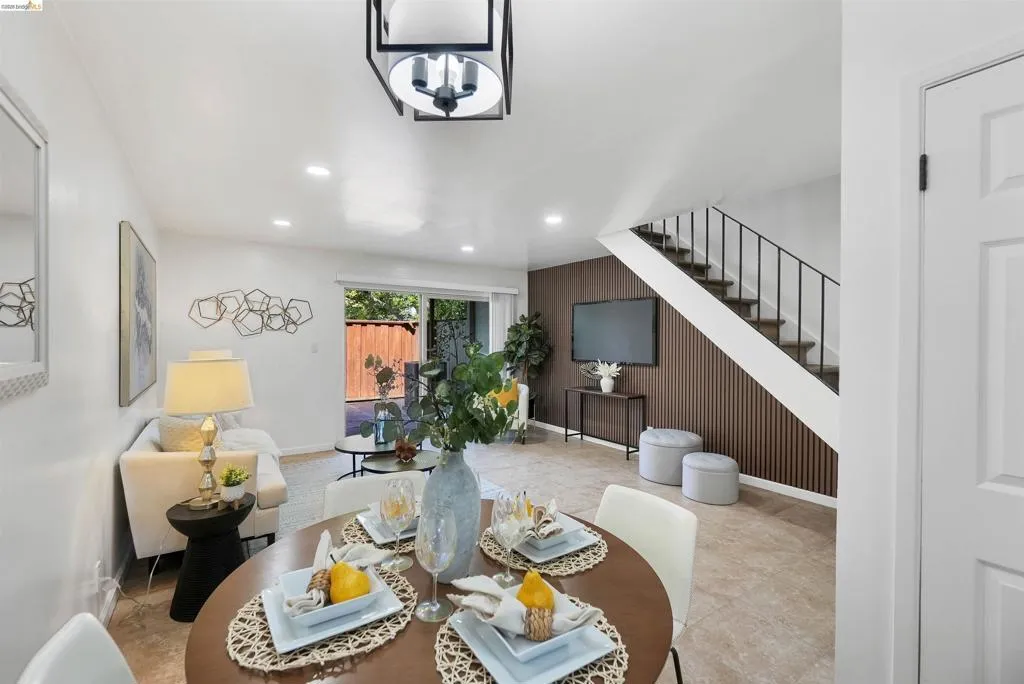 Open-concept living area with a contemporary chandelier, recessed lighting, and sliding glass door access to an outdoor space