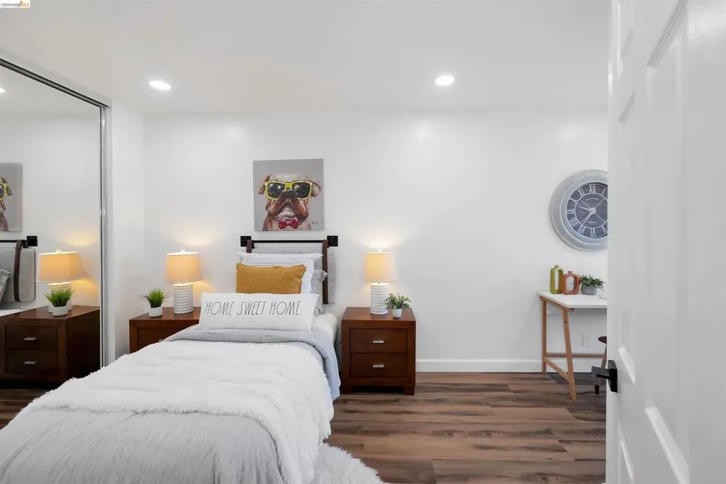 Room featuring wood-finish flooring, recessed lighting, and a mirrored closet door