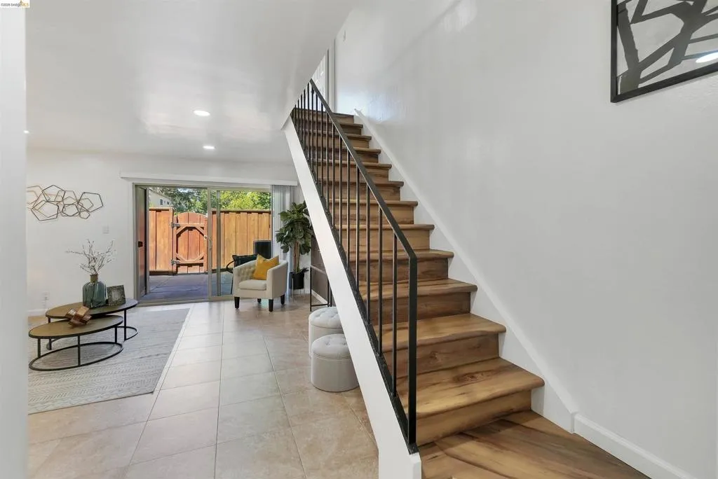 Staircase featuring wood-finish treads and a black metal railing