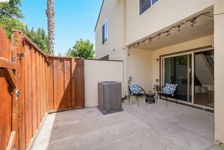 Private concrete patio with stucco exterior and a wood privacy​​‌​​​​‌​​‌‌​​‌​​​‌‌​​​‌​​‌‌​​‌‌​​‌‌​​​​ fence