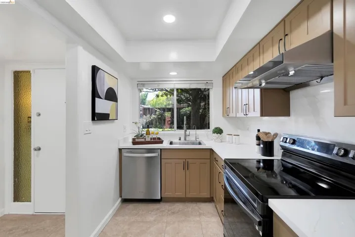Galley kitchen featuring light-toned cabinetry, white countertops, and a white tile backsplash