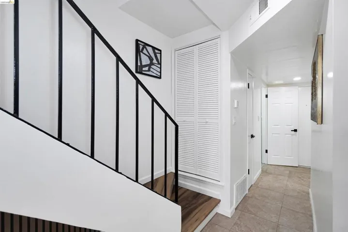 Staircase with black metal railings and wood-finish treads