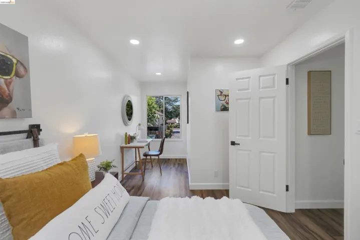 Interior room featuring wood-finish flooring, white walls, and recessed lighting
