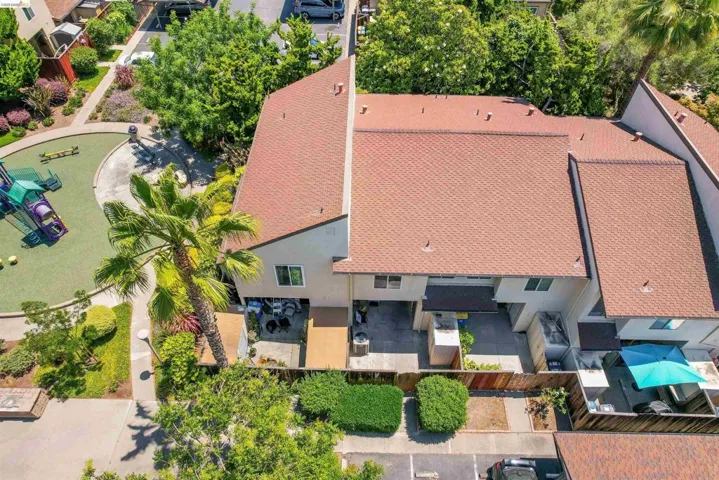 Townhome exterior featuring a red tile roof, private patio spaces, fenced yards, and a palm tree