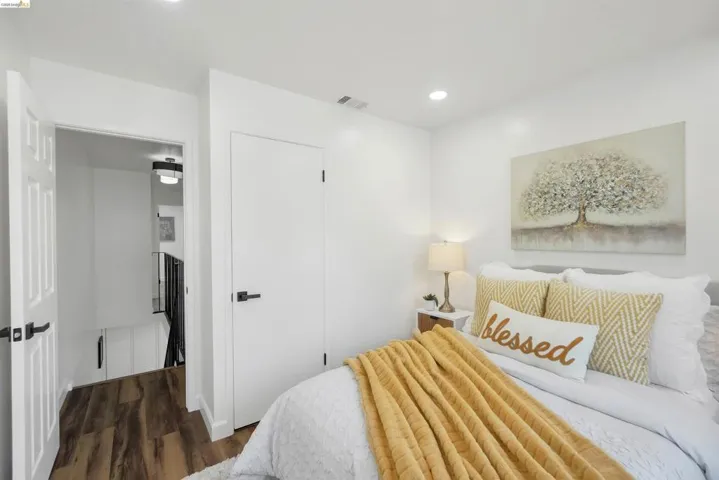 Bedroom featuring crisp white walls, recessed lighting, and wood-finish flooring