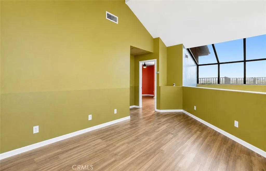 Another view of the third level, featuring a versatile bonus area and hallway leading to the primary bedroom and additional living spaces.