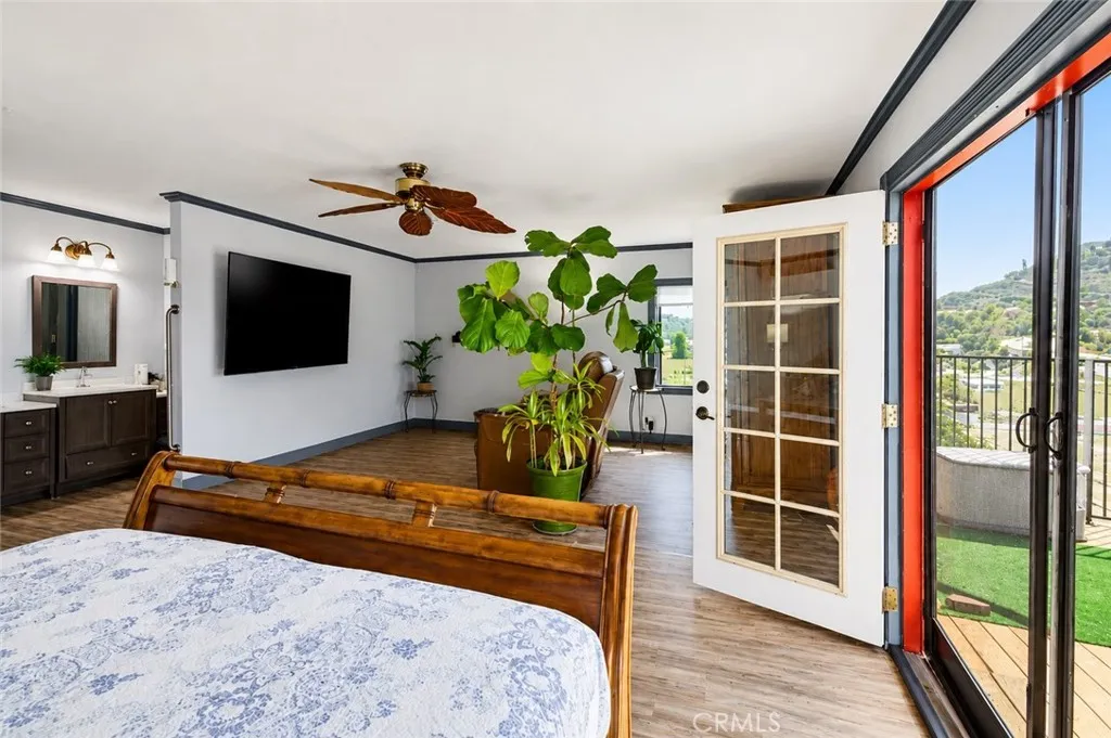 Spacious primary bedroom featuring French doors that open to a private deck with panoramic city views.