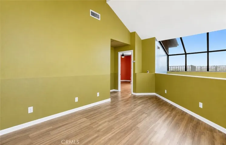 Another view of the third level, featuring a versatile bonus area and hallway leading to the primary bedroom and additional living spaces.