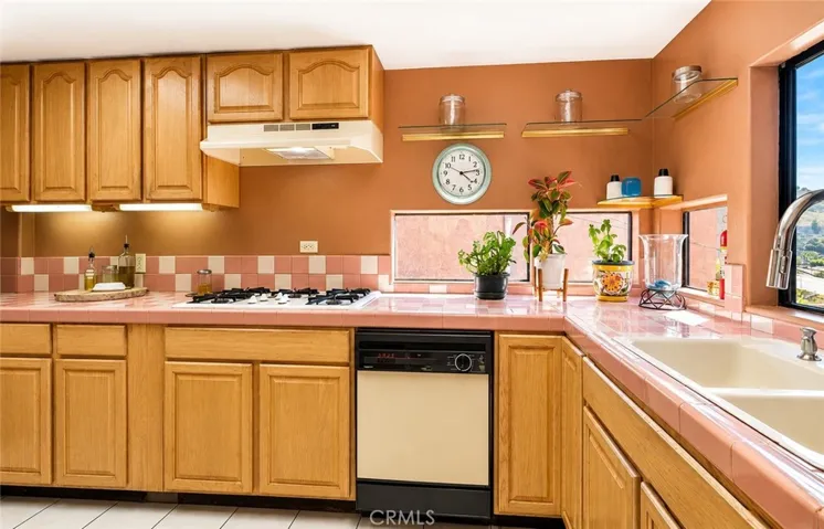 Another view of the spacious kitchen, featuring warm oak cabinetry and plenty of storage.