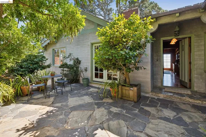 Irregular flagstone patio with ample foliage and adjacent to dining room through French Doors
