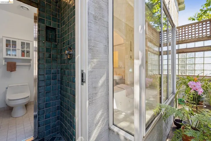 Shower enclosure with teal tile surround and built-in niche