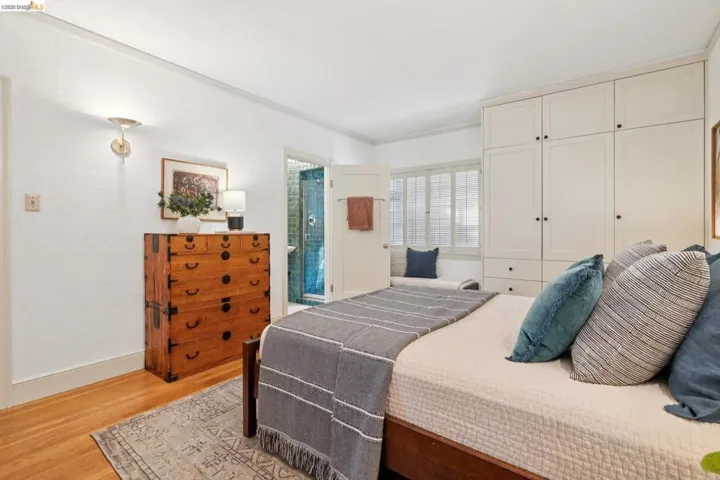 Wood-finish flooring with white baseboards and textured white walls