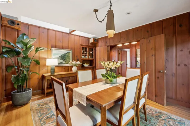 Wood-paneled room featuring wood-finish flooring and a central wooden table