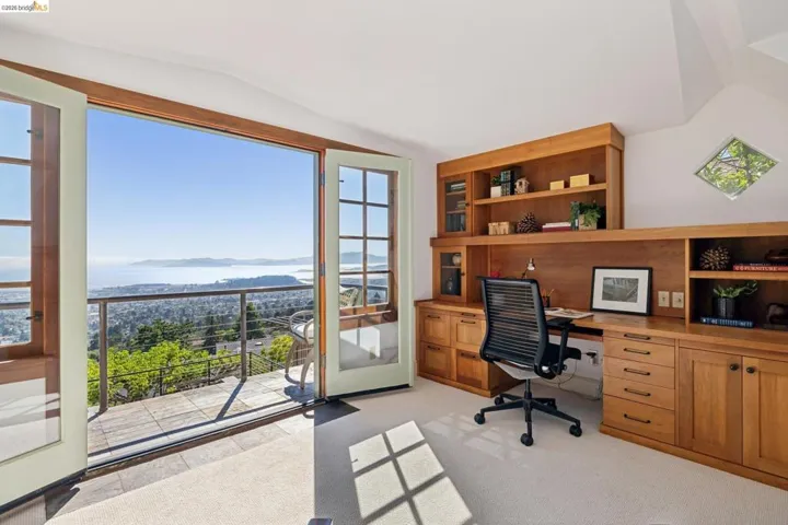 Expansive balcony with tiled flooring and cable railings, showcasing city and water scenery
