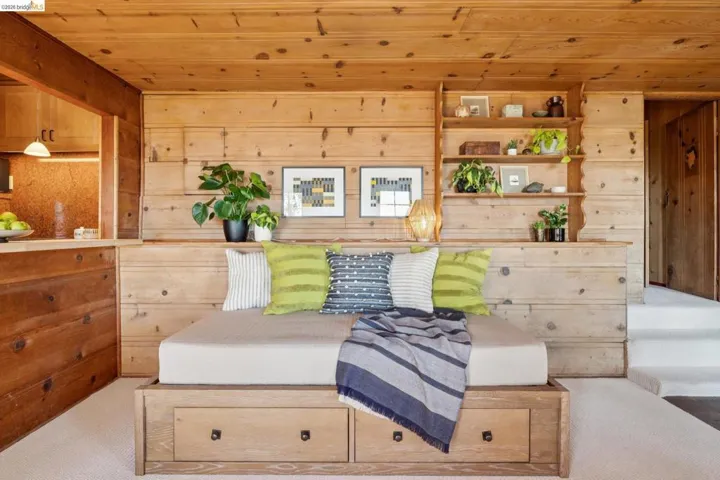 Wood-paneled room featuring a built-in daybed with integrated storage drawers