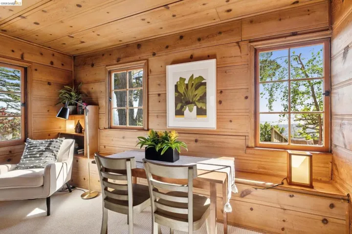 Wood-paneled room featuring multiple windows with outdoor scenery