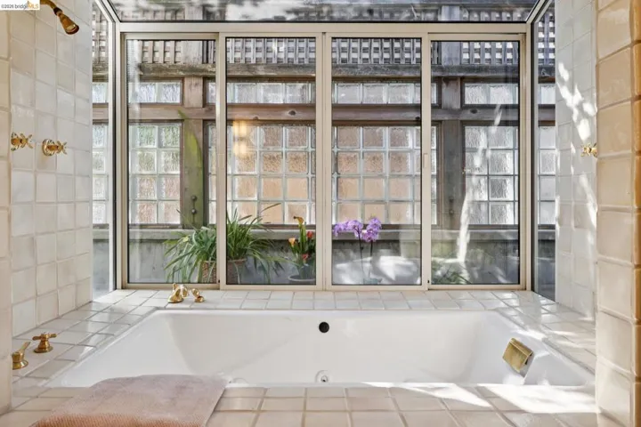 Soaking tub surrounded by square ceramic tiles