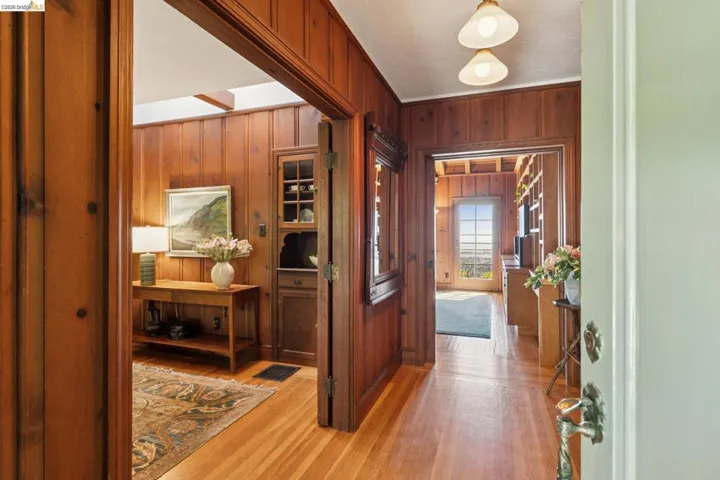 Entryway featuring hardwood flooring and extensive wood paneling