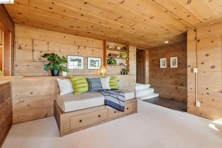 Wood-paneled room featuring a built-in daybed with integrated storage drawers