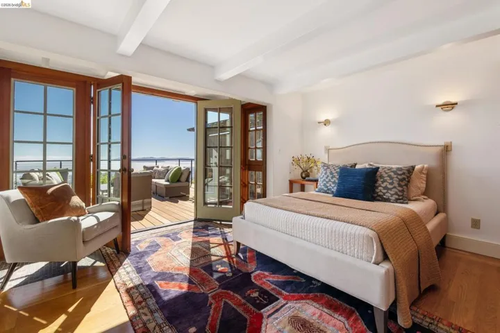 Hardwood flooring throughout, with exposed ceiling beams and wall-mounted sconce lighting