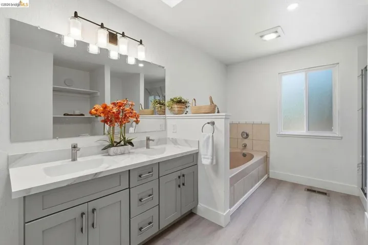 Dual vanity with gray shaker cabinetry, undermount sinks, and a white marble-finish countertop