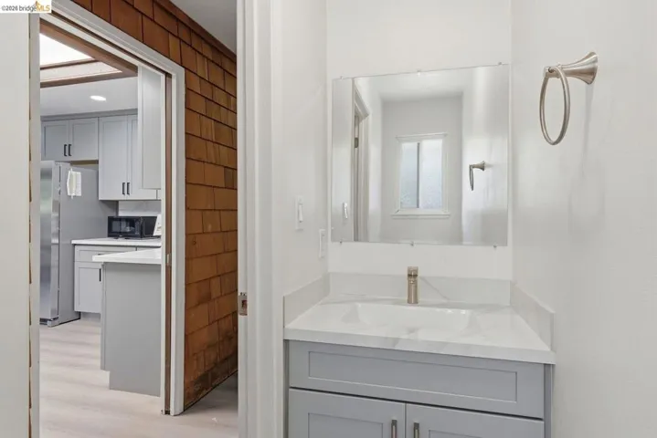 Half bathroom vanity with a rectangular undermount sink, a sleek single-handle faucet, and a large wall-mounted mirror