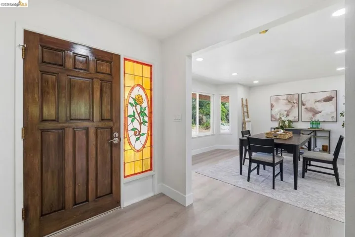 Paneled wood entry door with an oval stained-glass sidelight
