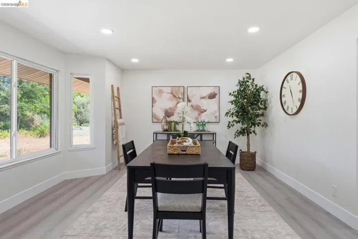 Dining area featuring bay windows, light wood-finish flooring, recessed lighting, and crisp white walls