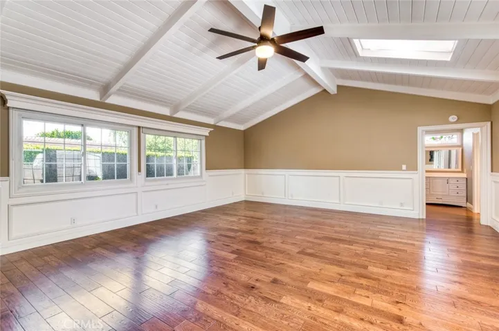 Massive primary bedroom suite with vaulted beam ceilings, ceiling fan, skylights and en-suite bathroom.