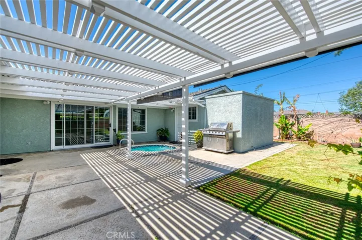 Private back yard with relaxing spa, BBQ, grassy lawn and fruit trees.